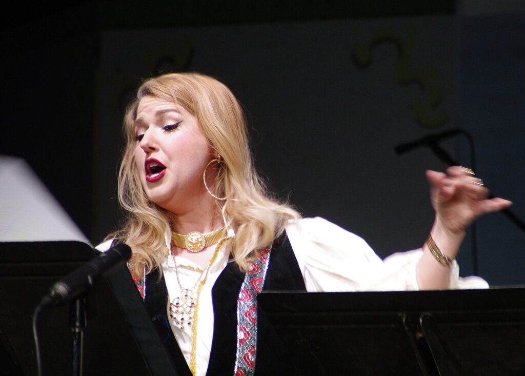 A woman singing in front of an audience.