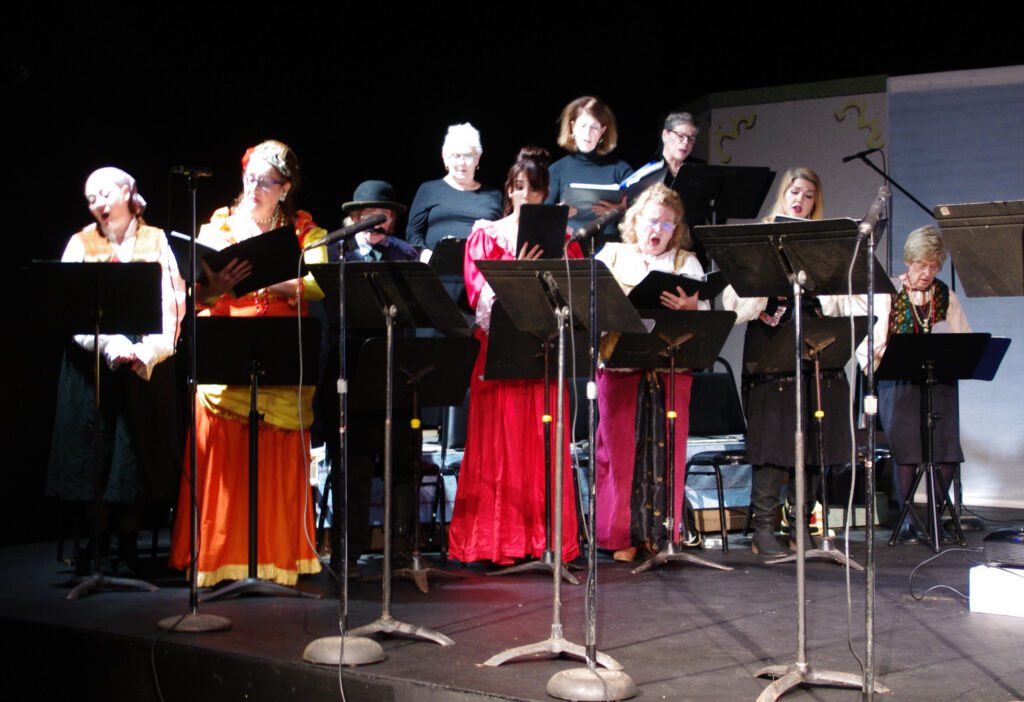 A group of people standing around each other on stage.